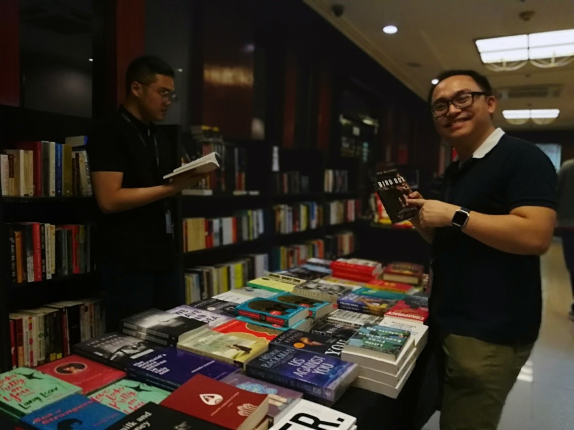 Night owls busy browsing books, with Keith proudly showing off his great find